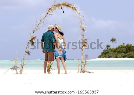 Couple kiss on Honeymoon Island in Aitutaki Lagoon Cook Islands.  Concept photo of couples travel , vacation, tourism , holidays, honeymoon, love,relationship.