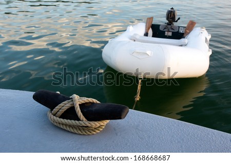 Rubber inflatable dinghy boat towed to a boat.