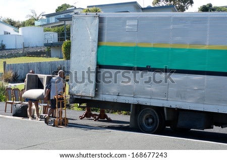 CABLE BAY, NZ - NOV 22:House moving with workers and truck on Nov 22 2013.According to U.S. Census Bureau, Individuals move 11.7 times in their lifetime.