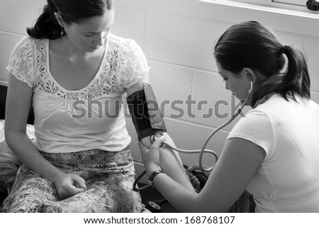 CABLE BAY, NZ:Midwife checks pregnant woman blood pressure on Dec 12 2013.In pregnancy, it\'s the fetal heart that builds up the blood pressure to drive its blood through the circulation. close up (BW)