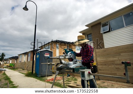 AUCKLAND,NZ - JAN 11:Chines builder works in new homes building site on JAN 11 2014.House prices are booming around New Zealand - with the average price of an Auckland city home rocketing to $735,692