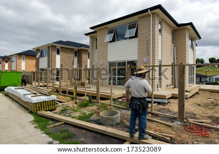AUCKLAND,NZ - JAN 11:Chines builder works in new homes building site on JAN 11 2014.House prices are booming around New Zealand - with the average price of an Auckland city home rocketing to $735,692