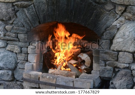 Outdoor fireplace with burning fire in a cold day. horizontal view