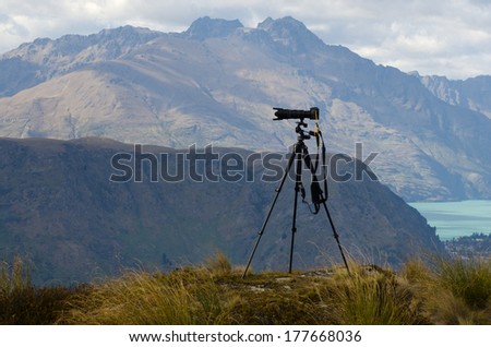 Professional camera with telephoto lens on a tripod during landscape photography outdoor.