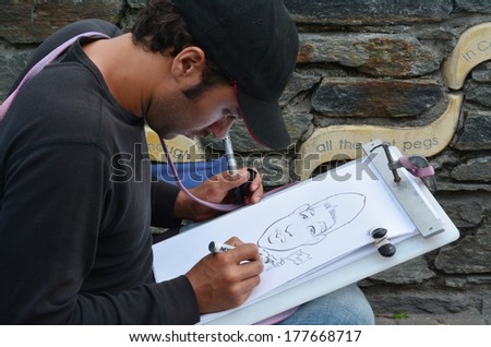 QUEENSTOWN, NZ - JAN 15:Caricature artist on Jan 15 2014.Caricature appeared in th 16th century and today many popular graphic artists have combined caricature with social and political satire.