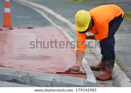 KAITAIA, NZ JAN 23:Road worker use finishing trowel tool on Jan 23 2014.The Road Maintenance crew has the responsibility for the day-to-day maintenance needs of the road system.