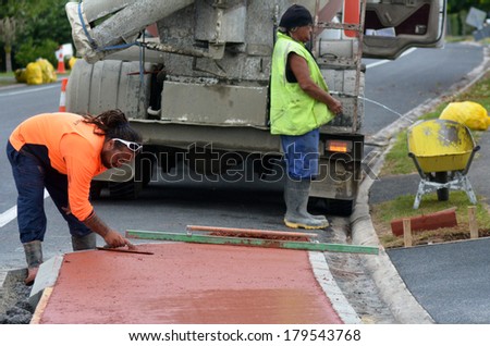 KAITAIA, NZ JAN 23:Road workers use finishing trowel tool on Jan 23 2014.The Road Maintenance crew has the responsibility for the day-to-day maintenance needs of the road system.