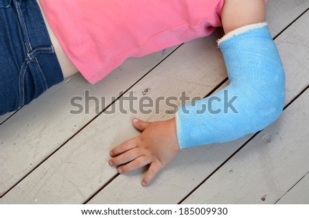 Child with a broken arm wearing a cast. Concept photo of child, children, health care, risk, danger, outdoor accidents, game accidents, playground accidents, home accidents.