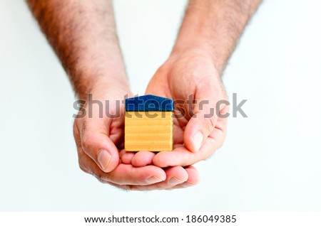 Man hands holds toy house isolated on white background with copy space.Concept photo of real estate business, home Insurance, house rental,buying, renting, mortgage, finance,service and repair costs