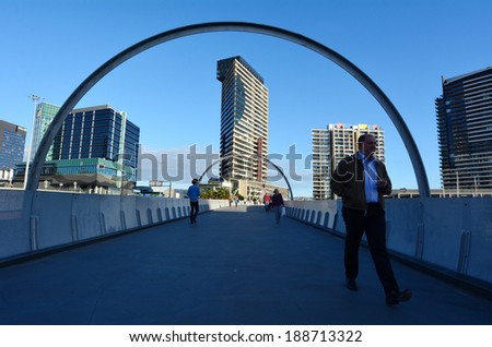 MELBOURNE,AUS - APR 14 2014:Pedestrians cross on Webb Bridge.It\'s an award winning bridge forming a cycling and pedestrian link to the main part of Docklands, through Docklands Park.