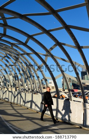 MELBOURNE,AUS - APR 14 2014:Pedestrian cross on Webb Bridge.It\'s an award winning bridge forming a cycling and pedestrian link to the main part of Docklands, through Docklands Park.