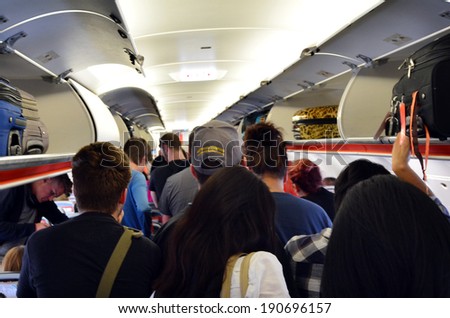MELBOURNE - APR 10 2014:Interior of airplane with passengers get on board.According to Us Travel Association, the average age of leisure travelers is 47.5 years old.