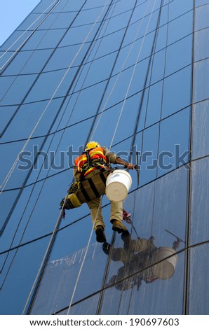 MELBOURNE - APR 14, 2014:Window cleaner works on high rise building.Window cleaning is considered one of the most dangerous job in the world.Several window cleaners die each year and many are injured
