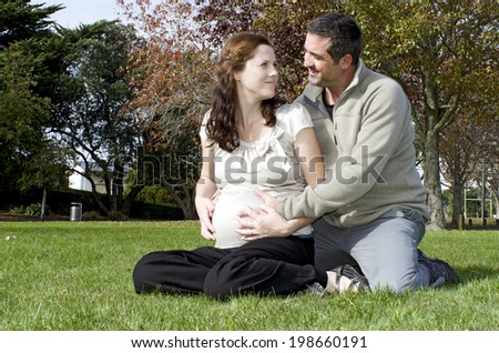 Pregnant woman and her husband during pregnancy outdoor at the park. Concept photo of women healthy life style and health care. copyspace