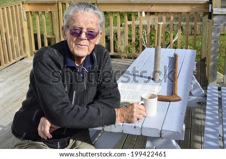 Portrait of happy old man in his 90\'s. sit in his home garden and hot drink. Concept photo of senior citizen, retirement, pensioner, health and aging.