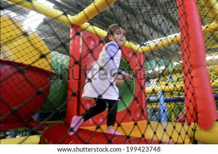 Little girl play in indoor playground.