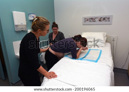 AUCKLAND - JUNE 07 2014:Pregnant woman having contractions in birthing suite of Maternity Hospital.In the 1960s, Igor Tjarkovsky,swimming instructor and midwife, popularized water birth in Russia.
