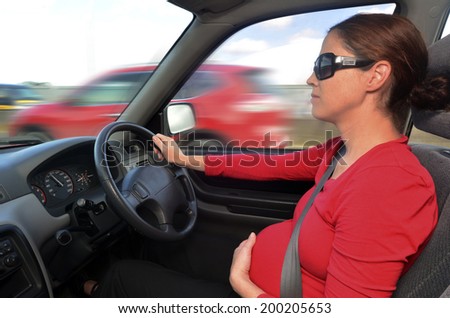Young pregnant woman drive a car during pregnancy. Concept photo of pregnancy, pregnant woman lifestyle , transportation and health care.