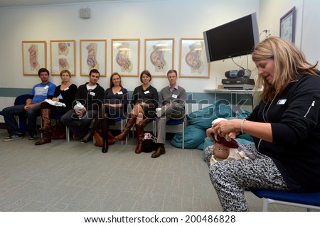 AUCKLAND - JUNE 09 2014:Midwife teaches and demonstrates childbirth to a pregnant woman and their partners.Only 5% of babies are born on their due date. Most babies arrive anywhere between 37 to 42 weeks