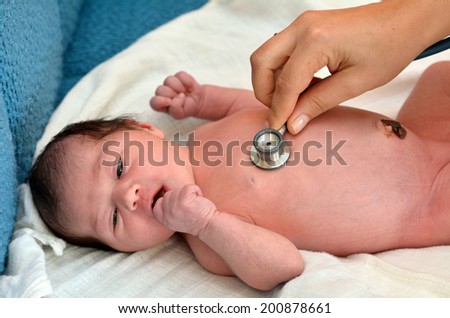 AUCKLAND - JUNE 14 2014:Midwife checks newborn (Naomi Ben Ari age 0) heart rate.Heart rate of normal newborns is 130 to 150 beats per minute,it\'s double then normal adult heart rate (60 to 100 beats).