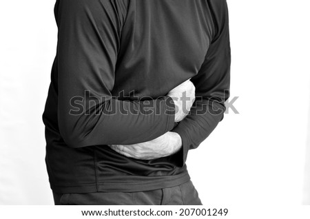 Man with stomach pain standing against white background. Torso and hands. Concept photo of healthcare and Medical (BW)
