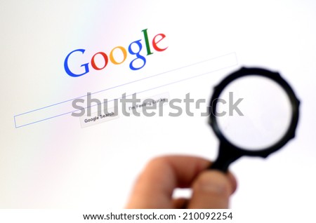 AUCKLAND - AUG 10 2014:Man hand holds Magnifying glass against Google homepage.According to the Washington Post the NSA uses Google cookies to pinpoint targets for hacking.