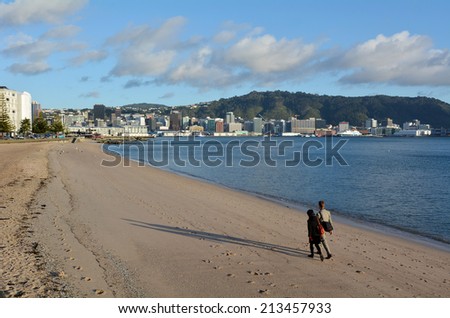 WELLINGTON -  AUG 21 2014:Couple walks on Oriental bay beach during sunrise.Wellington is the capital city and second most populous urban area of New Zealand, with 397,900 residents.