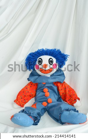 Handmade clown doll sit on white background. Concept photo of happy,happiness, sadness, sad, child, childhood, toy. copyspace