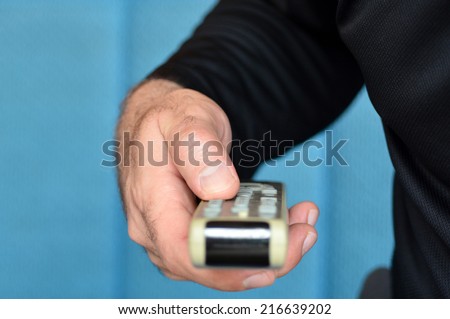 Man hands holds remote control. Concept photo of man, watching tv, lifestyle, media.