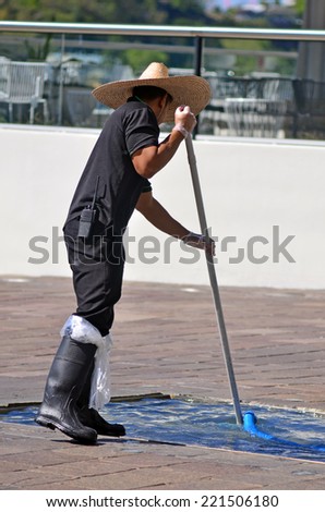 BRISBANE, AUS - SEP 25 2014:Swimming pool service technician clean a pool.