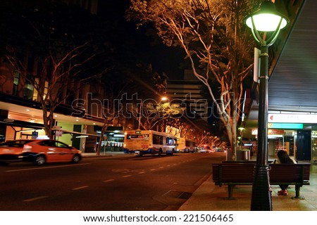 BRISBANE - SEP 25 2014:Woman waits for Brisbane Transport Bus at night.Brisbane Transport operating bus services under the TransLink integrated public transport scheme in Brisbane.