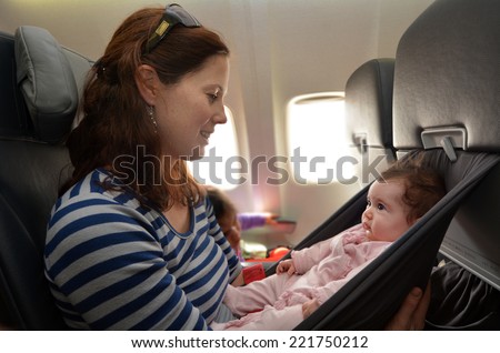 Mother carry her infant baby during flight.Concept photo of air travel with baby.