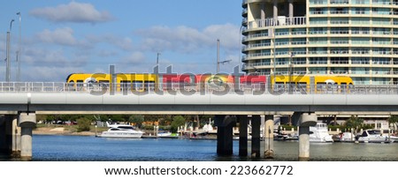 GOLD COAST, AUS - OCT 13 2014:Gold Coast Light Rail G cross over Sundale Bridge and Southport skyline in Gold Coast Queensland, Australia.The line opened on July 2014 and it 13 Km (8.1 mi) long.