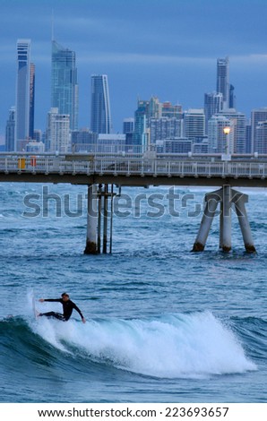 GOLD COAST - OCT 10 2014: Surfers rids a wave in the Spit beach.It is a very popular surfing beach in Surfers Paradise Gold Coast Queensland, Australia.