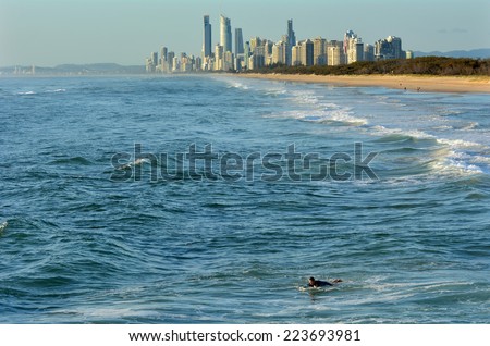 GOLD COAST - OCT 13 2014: Surfer catching waves in the Spit beach.It is a very popular surfing beach in Surfers Paradise Gold Coast Queensland, Australia.
