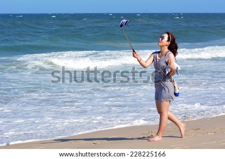 SURFERS PARADISE, AUS - NOV 01 2014:Asian woman take selfie photo on the beach. Over 1 Million selfies Are taken each day.Instagram has over 53 million photos tagged with the hash tag #selfie.