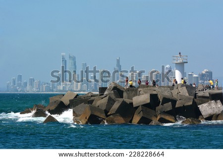SURFERS PARADISE, AUS - OCT 28 2014:Visitors on Gold Coast Seaway with Surfers Paradise skyline.It\'s one of Australia\'s iconic coastal tourist destinations, drawing 10 million tourists a year.