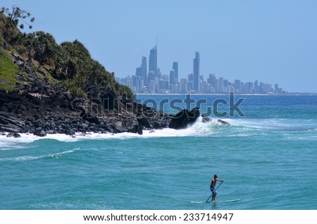 SURFERS PARADISE - NOV 09 2014:Man on stand up paddling in Surfers Paradise.It one of Australia's iconic coastal tourist destinations, drawing 10 million tourists every year from all over the world.