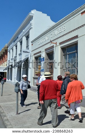 NAPIER, NZL - DEC 03 2014:Visitors with a tour guide in Napier.It\'s a popular tourist city with a unique 1930s Art Deco architecture, built after the city was razed in the 1931 Hawke\'s Bay earthquake.