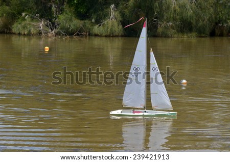 AUCKLAND, NZL - DEC 21 2014:One remote controlled sailing wooden yacht race in a pond.The racing is governed by the same Racing Rules of Sailing that are used for full-sized crewed sailing boats