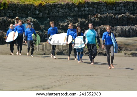 MURIWAI, NZL -  JAN 01 2015:People learn to surf in Muriwai beach.It\'s a very popular beach in New Zealand known for it beauty and for its outdoor activities such as swimming, surfing and fishing.