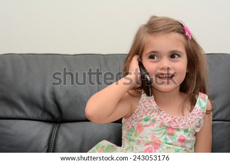 Happy little girl speak on the phone at home. Concept photo of long distance ,call ,communication, telephone, service, overseas, conversation, technology