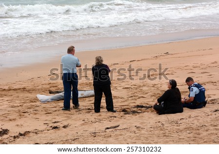 CABLE BAY, NZL - MAR 02 2015:Police officers investigate eyewitness that found body washes ashore.According to International Rewards Center about 607 people go missing every day around the world.