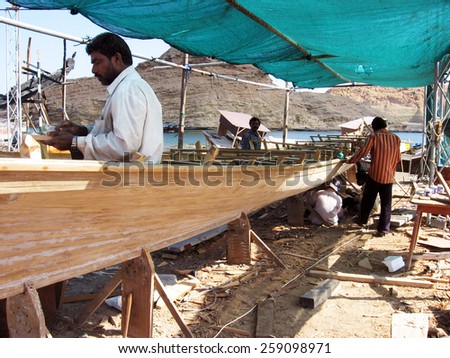 SUR,OMAN - DEC 30 2007:Traditional Omani wood boats (Dhows) builders in a workshop in Sure Fishermen village Sur, Oman. It\'s one of the most famous cities in the Persian Gulf in building wooden boats.