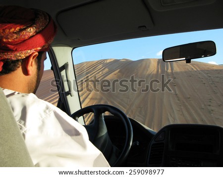 WAHIBA DESERT, OMAN - DEC 2 2007: Omani man Dune Bashing in a 4X4 car in Wahiba Sands Desert, Oman.The highest sand dunes in the Wahiba Sands Desert measure up to 100 meters (330 ft) high