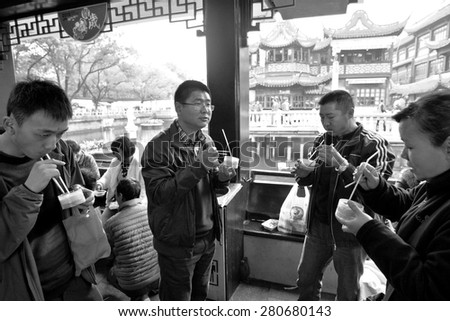 SHANGHAI, CN - MAR 17 2015:Chines people eats Dim sum dumplings food at Yuyuan Tourist Mart in Shanghai, China.Dim sum dumplings it\'s the most popular and famous food in Shanghai, China