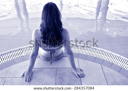 Young woman enjoying natural mineral salty water in indoor pool in a resort in the Dead Sea, Israel. Concept  copy space