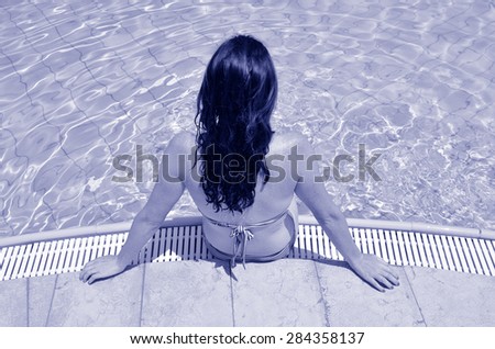 Young woman enjoying natural mineral salty water in outdoor pool in a resort in the Dead Sea, Israel
