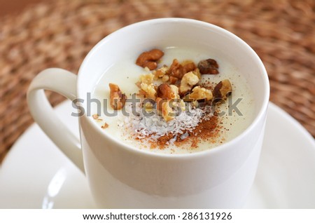 Sahlab Salep drink with shredded coconuts, crushed nuts and  pinch of cinnamon.Food and drinks background texture.