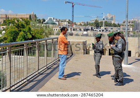 JERUSALEM - MAY 05 2015:Israeli border patrol policewomen checking Arab man ID and work permits.The force securing Israel borders and assisting IDF and law enforcements in the West Bank and Jerusalem.
